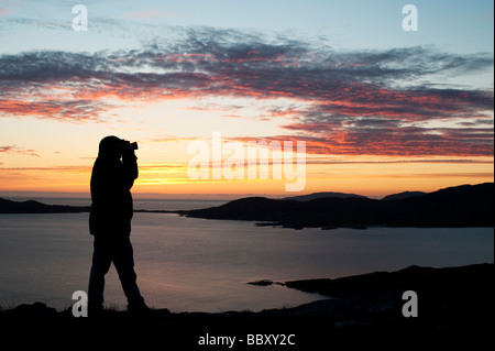 Silhouette eines Fotografen bei Sonnenuntergang mit Blick auf z. Island, Isle of Harris, äußeren Hebriden, Schottland Stockfoto