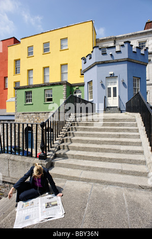 Person liest eine Zeitung vor bunt bemalte äußeren Gebäuden des Dublin Castle Dublin Irland Stockfoto