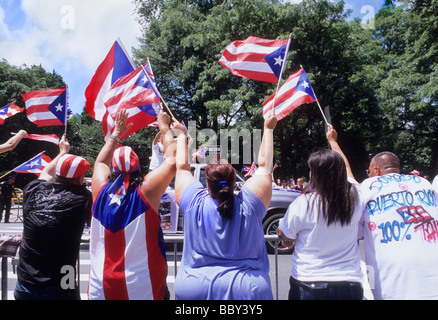 Puerto-ricanische Tagesparade. Die Menge auf der Straße jubelt und beobachtet auf der Fifth Avenue. Übergewichtige Menschen, die Puerto-ricanische Flaggen schwenken. Veranstaltung des Kulturfestivals Stockfoto