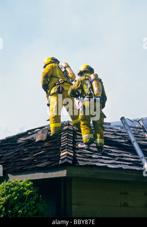 Feuer Firefigher Feuerwehrmann Dach löschen löschte Sauerstoff sicher Gefahr Gefahr Geschick Arbeit Beruf Notfall Hausgarage Stockfoto