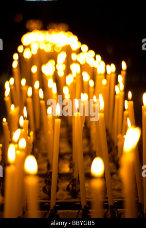 Votiv-Kerzen brennen in einer Kirche Stockfoto