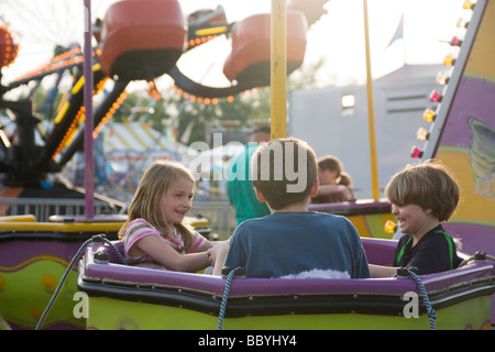 Kinder sitzen im Vergnügungspark Stockfoto