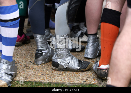 Teilnehmer-Schuhe mit Klebeband an ihren Knöcheln vor Beginn des Rennens Mad Maldon Schlamm im Fluss Blackwater bei Maldon Essex statt Stockfoto