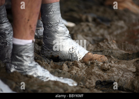 Teilnehmer-Schuhe mit Klebeband an ihren Knöcheln vor Beginn des Rennens Mad Maldon Schlamm im Fluss Blackwater bei Maldon Essex statt Stockfoto