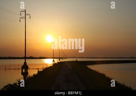 Sonnenuntergang und Silhouette macht Kabel Pylonen, Versorgung Insel Albarella, Italien Stockfoto