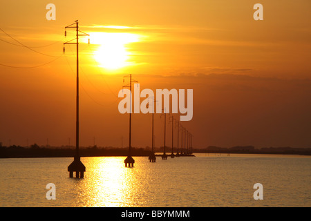 Sonnenuntergang und Silhouette macht Kabel Pylonen, Versorgung Insel Albarella, Italien Stockfoto