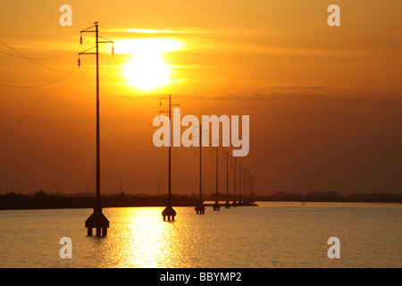 Sonnenuntergang und Silhouette macht Kabel Pylonen, Versorgung Insel Albarella, Italien Stockfoto