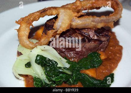 Gegrilltes Rindfleisch Filet Steak, garniert mit Zwiebel Ringe Baby Bok Choy Kohl Stockfoto