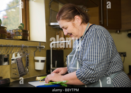Frauenbeschneidung, 67 Jahre alt, Frühlingszwiebeln in der Küche Stockfoto