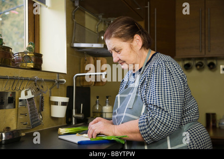 Frauenbeschneidung, 67 Jahre alt, Frühlingszwiebeln in der Küche Stockfoto