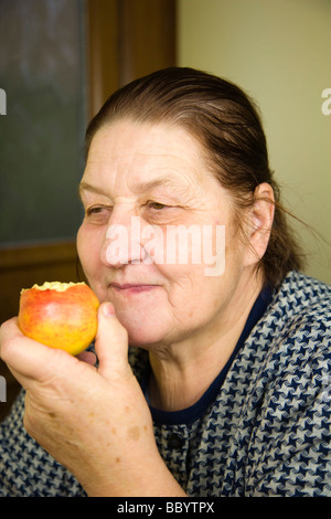 Frau, 67 Jahre alt, einen Apfel essen Stockfoto