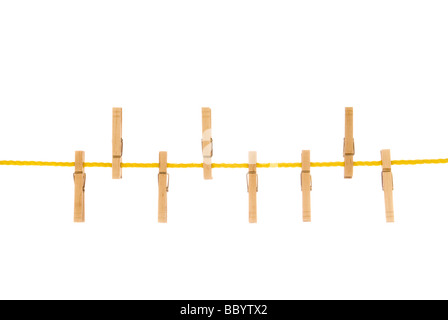 Wäscheklammern an einem gelben Seil isoliert auf einem weißen Hintergrund Bild wurde in einem beleuchteten weißen Hintergrund gedreht und ist kein Ausschnitt Stockfoto