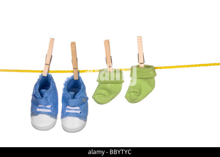 Ein paar Baby-Schuhe und Socken von einer Wäscheleine hängen Stockfoto