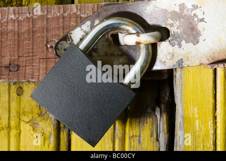 Metall Vorhängeschloss auf gelben Holztür Stockfoto