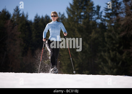 Junge Frau läuft durch Schnee mit Schneeschuhen in der Nähe von Mount Hood, Oregon. Stockfoto