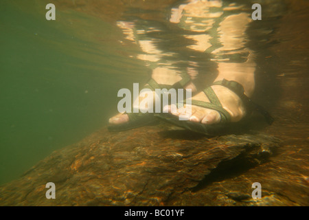 Unterwasser-Blick eines Mannes Füße in Sandalen. Stockfoto