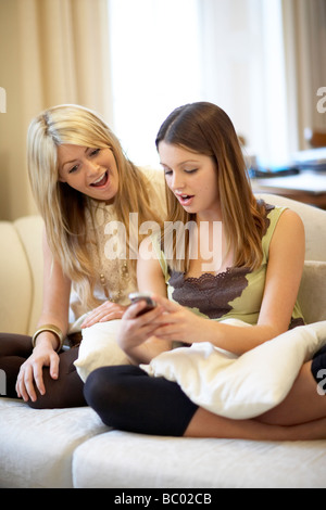 Zwei Mädchen im Teenageralter Blick auf ein Mobiltelefon Stockfoto