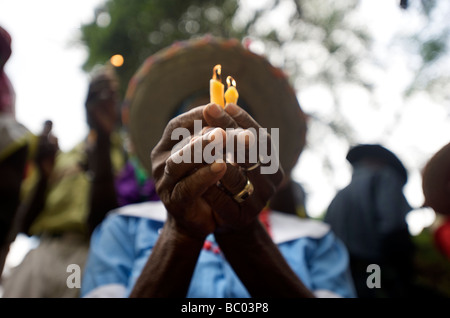 Eine Frau hält Kerzen beim beten während eines Voodoo-Festivals in Haiti. Stockfoto