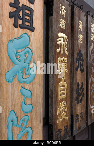 Traditionelle hölzerne Schilder werben verschiedene Arten Jizake oder regionalen Sake Reiswein in einem Sake-Shop in Takayama Stockfoto