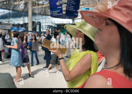Frauen, die in Richtung Ascot Racecourse ab Waterloo Station in London Stockfoto