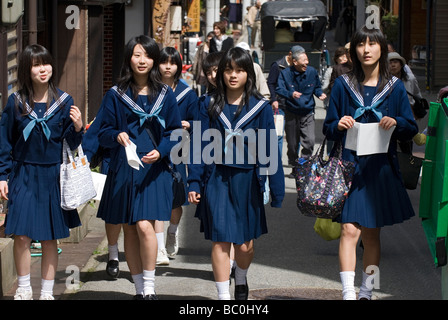 Eine Gruppe von Schulmädchen Uniformen Segler genießen einen Spaziergang entlang einer Straße in Takayama während ihrer Klassenfahrt Stockfoto