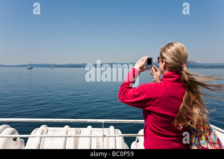 Junge Frau, die das Fotografieren von einem Boot aus Victoria BC Kanada Stockfoto