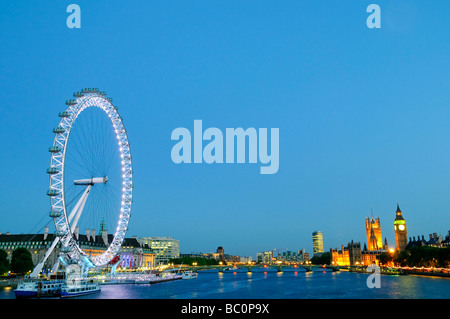 London Eye Big Ben Gothic Revival beleuchtete Twilight River Thames London United Kingdom | LONDON, United Kingdom — das London Eye und der Elizabeth Tower des Palace of Westminster ankern in der Dämmerung gegenüber den Ufern der Themse und umrahmen die Länge der Skyline von South Bank. Marks Barfield Architects’ 135-Meter-Rad (443 Fuß) wurde 2000 eröffnet, während Charles Barry und Augustus Pugin den Gothic Revival parliament Complex wiederaufbauten, nachdem ein Brand im Jahr 1834 den Vorgänger zerstört hatte. Stockfoto