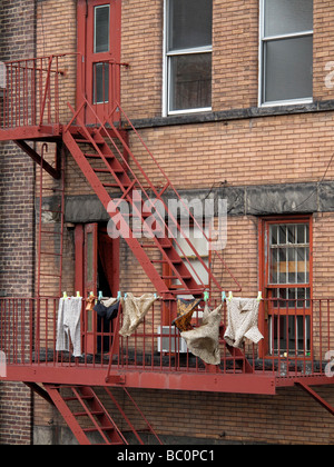 Wäsche trocknen auf eine Feuerleiter in New York City. Stockfoto