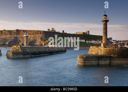 Der Leuchtturm auf Whitby Pier mit St. Hilda Abtei und Str. Marys Kirche auf den Klippen im Hintergrund Stockfoto