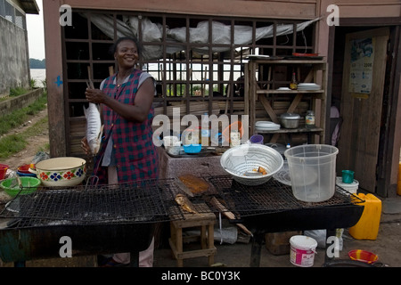Frau, die Zubereitung von Fisch zum Grillen im freien Fisch Bar Restaurant am Ufer des Wouri Fluss Douala Kamerun Westafrika Stockfoto