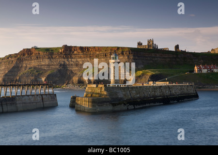 Der Leuchtturm auf Whitby Pier mit St. Hilda Abtei und Str. Marys Kirche auf den Klippen im Hintergrund Stockfoto