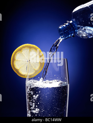 Abgefülltes Wasser in ein Glas mit einer Scheibe Zitrone. Stockfoto
