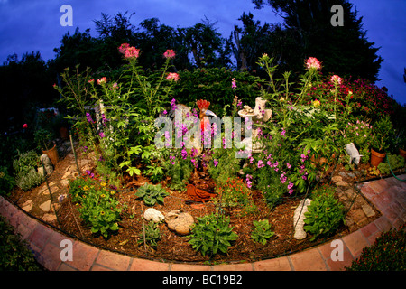 Lustige Figuren von einem Hahn, geflügelter Frosch und Nilpferd schmücken einen Southern California-Garten in der Dämmerung. Stockfoto