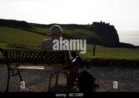 Einsamer Mann saß auf einer Bank mit Blick auf Meer, Duntulm Bay, Isle Of Skye, innere Hebriden, Westküste von Schottland, UK Stockfoto