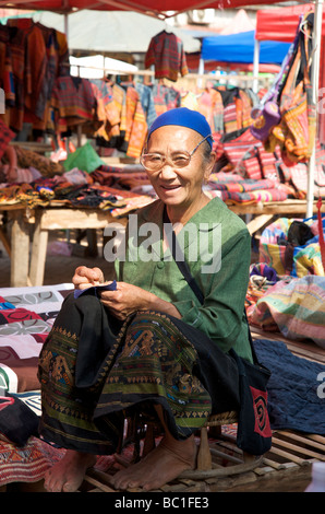 Eine alte Lao Frau Nähen auf ihrem Textil-Stall Prabang Markt Stockfoto