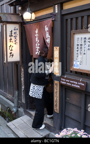 Eine Frau betritt ein Restaurant suchen in Takayama auf Sannomachi Straße in der Altstadt Stockfoto