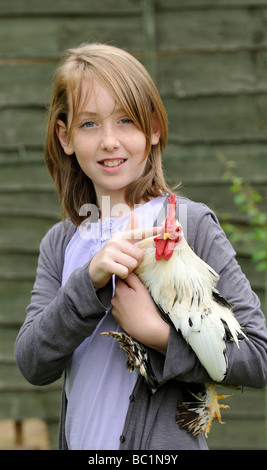 Junges Mädchen hält ihr Haustier weißen bärtigen belgischen Bantam-Hahn Stockfoto