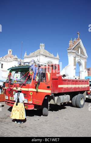 Aymara-Paar schmückt ihren Lastwagen vor der Kathedrale vor einer Segenszeremonie, Copaba, Bolivien Stockfoto