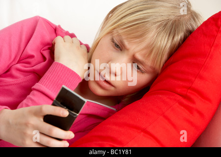 Junges Mädchen Text zu lesen und schauen besorgt Stockfoto