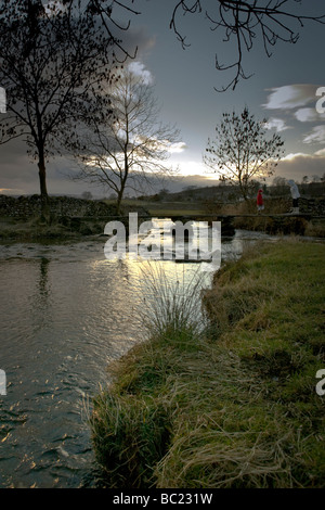 Wandern in den Yorkshire Dales, in der Nähe von Austwick, eine Großmutter und ihre Nichte zu überqueren die eine Steinbrücke über den Fluss Stockfoto