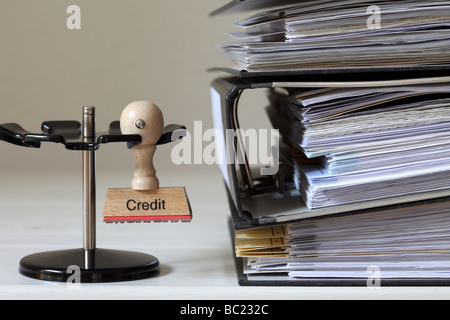 Stempel mit Inschrift Credit neben einem Haufen von Dateien Stockfoto