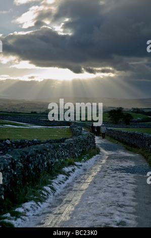 Eine Familie, die zu Fuß auf einem eisigen Maultierweg in den Yorkshire Dales, in der Nähe von Austwick. Stockfoto