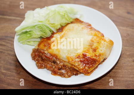 Frische leckere italienische Stil herzhaftes Hackfleisch Lasagne Pasta Essen gekrönt mit geschmolzenem Käse ohne Menschen und ein Salat auf Teller serviert Grnish Stockfoto