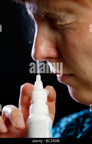 Frau benutzt ein Nasenspray Stockfoto