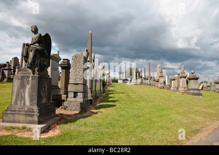 Ein steinerner Engel steht im Mittelpunkt der Zeilen Grabsteine und Denkmäler in Glasgows Nekropole, die viktorianischen Gräberfeld. Stockfoto