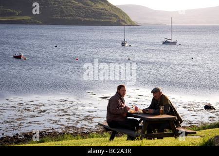 Zwei Männer trinken an einem Picknicktisch, Stein, Isle Of Skye, innere Hebriden, Westküste von Schottland, UK Stockfoto