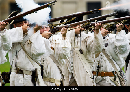 Männer gekleidet in revolutionärer Krieg Periode Soldaten Uniformen feuern Musketen im Fort Adams in Newport, Rhode Island. Stockfoto