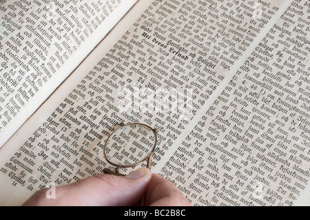 Hand, die ein paar Kneifer Brille über schwedische Bibel. Stockfoto