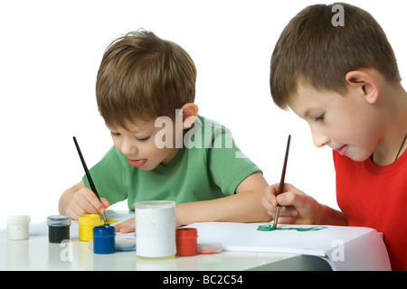 Zwei Jungs in grün und Rot-T-Shirts zeichnen Gouache setzen eine Zunge isoliert auf weiss Stockfoto