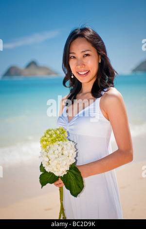 Asiatische Braut und Bräutigam spazieren Sie am Strand von Lanikai, wie sie ihr Leben als Ehepaar nach ihrer Hochzeit freuen Stockfoto